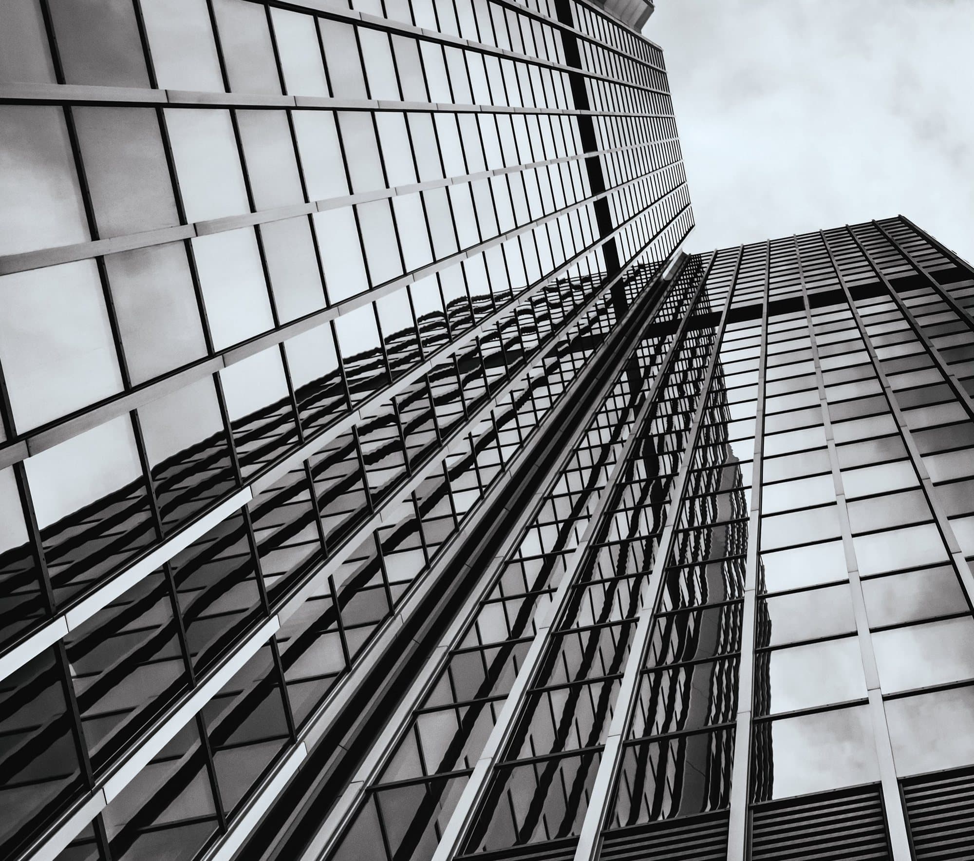 Glass curtain-wall tower rising against the sky